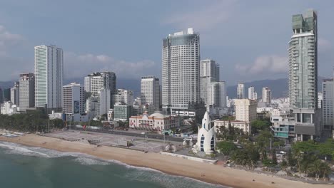 Una-Perspectiva-Aérea-Inmersiva-Del-Horizonte-De-Nha-Trang,-Donde-Las-Nubes-Bailan-Juguetonamente-Sobre-El-Paisaje-Urbano,-Proyectando-Sombras-En-Constante-Cambio-Sobre-Las-Bulliciosas-Calles