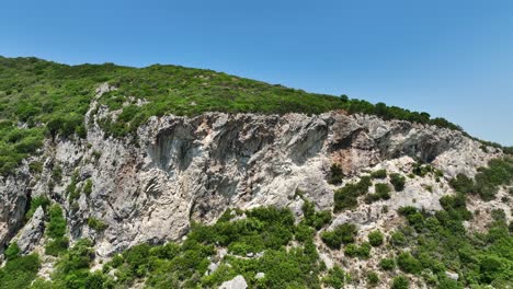 Üppiger-Grüner-Wald-Bedeckt-Die-Klippen-Der-Insel-Korfu-In-Griechenland-Unter-Einem-Klaren-Himmel,-Luftaufnahme