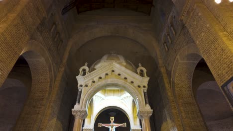 Solemn-interior-of-the-Catedral-Metropolitana,-Medellin,-with-its-iconic-crucifix-and-arched-brickwork,-embodying-serene-spirituality