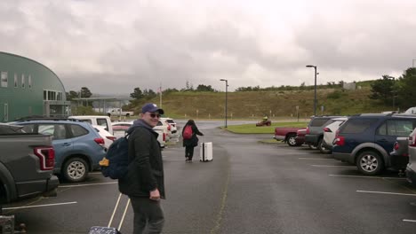 Los-Viajeros-Caminan-Con-Equipaje-En-El-Estacionamiento-Del-Aeropuerto-Regional-Del-Suroeste-De-Oregon-En-Coos-Bay-North-Bend