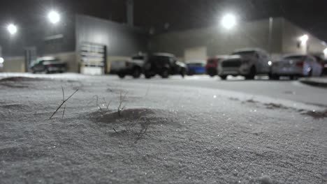 Parking-of-warehouse-facility-covered-in-snow-low-level-video-at-night