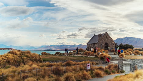 Tourists-explore-grounds-Good-Shepherd-Church-in-Tekapo,-New-Zealand,-timelapse