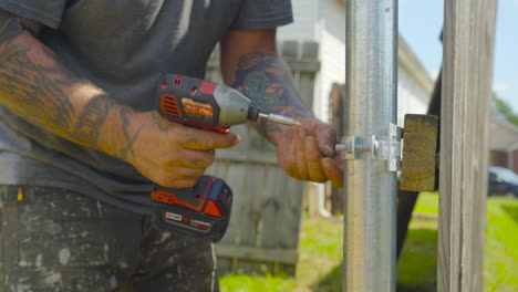 Handyman-screws-bracket-to-privacy-fence.-Tilt-down