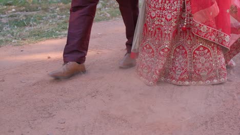 Feet-Of-Indian-Bride-And-Groom-Walking-On-Sandy-Pathway-Outdoor