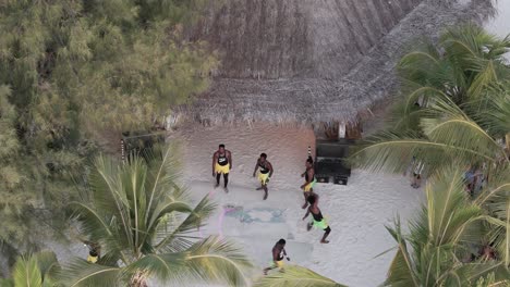 Luftaufnahme-Mit-Blick-Auf-Die-Aufführung-Farbenfroher-Athletischer-Tänzer-Am-Michamvi-Kae-Beach-In-Sansibar