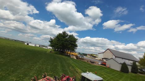 Working-Tractor-on-green-agricultural-field-in-american-countryside,-USA