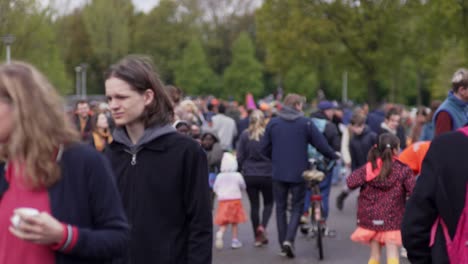 People-walking-strolling-and-passing-by-at-Vondelpark-during-King's-day-in-spring