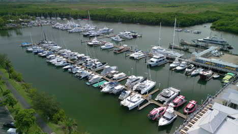 Aerial-Drone-Closeup-above-Boats-docked-in-Australian-Port-Douglas-Green-Water-landscape