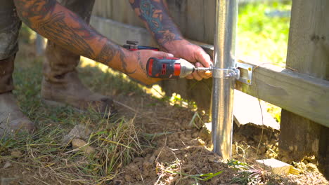 Screwing-a-bracket-to-a-wooden-fence