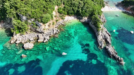 Limni-beach-glyko-in-corfu,-vibrant-turquoise-waters-hugging-rocky-coastline,-greece,-summer-vibe,-aerial-view