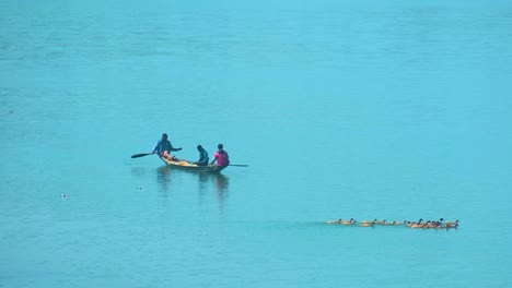 Local-Fishermen-On-A-Wooden-Canoe-Boat-With-Swimming-Ducks-Over-Tranquil-Lake-In-Bangladesh