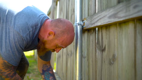 Worker-screwing-fence-to-a-metal-post