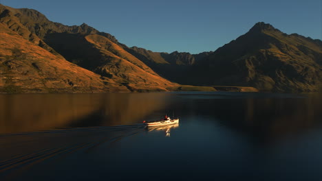 TSS-Earnslaw-steamship-at-sunset-on-Lake-Wakatipu-near-Queenstown,-New-Zealand---aerial-parallax