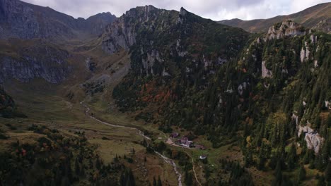 Autumn-colors-adorn-the-Bucegi-Mountains-surrounding-Malaiesti-Chalet,-aerial-view