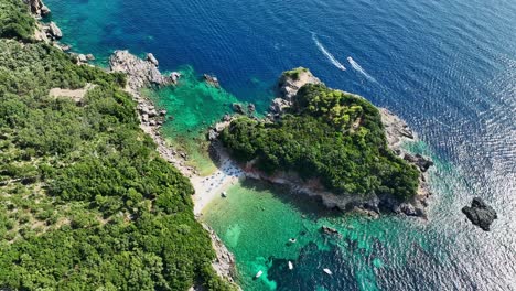 Limni-beach-glyko-on-corfu-island,-shimmering-ionic-sea-and-lush-greenery,-aerial-view