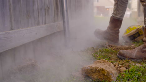 Construction-worker’s-rugged-boots-amidst-a-cloud-of-dust-while-working-outdoors