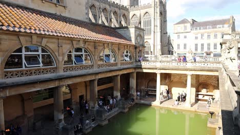 Edificio-Histórico-En-Bath,-Inglaterra-Con-Turistas-Y-Video-Desde-Arriba-Inclinándose-En-Cámara-Lenta