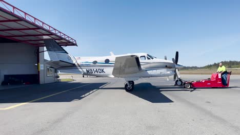 Cal-Ore-Life-Flight-Flugzeug-In-Den-Hangar-Geschoben-Durch-Bodenpersonal-Am-Crescent-City-Airport,-Kalifornien