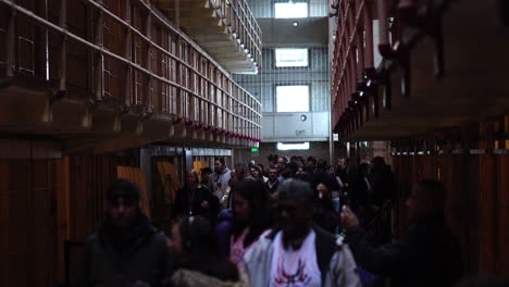 San-Francisco-CA-USA,-Tourists-Walking-in-Alcatraz-Prison-Cellhouse,-Times-Square-Path-Between-Cells