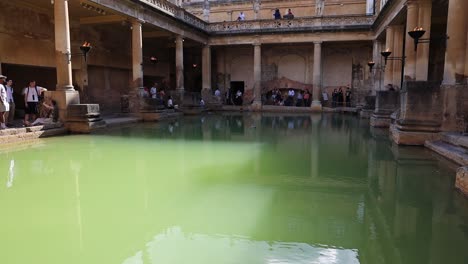 Historic-building-in-Bath,-England-with-tourists-and-video-tilting-up-in-slow-motion