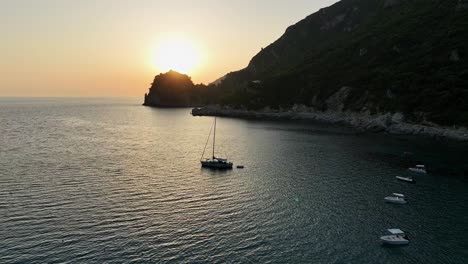 Veleros-Anclados-En-Una-Tranquila-Bahía-En-La-Isla-De-Corfú-Durante-Una-Serena-Puesta-De-Sol.