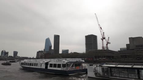 Shot-of-boat-cruise-in-River-Thames-near-Blackfriars-bridge-under-a-cloudy-day-in-London,-England