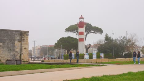 Profile-view-of-Red-and-white-lighthouse-in-the-historic-"Vieux-Port"-in-La-Rochelle,-France