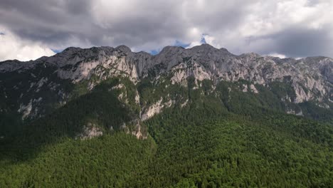 Majestuosas-Montañas-De-Piatra-Craiului-Con-Frondosos-Bosques-Bajo-Cielos-Nublados,-Toma-Aérea