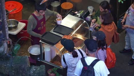 People-lineup-to-buy-famous-freshly-made-Taro-balls-dessert-at-Jiufen's-old-street-in-the-charming-mountain-village-town,-a-popular-tourist-attraction-of-Taiwan