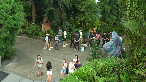 People-wandering-around-the-glass-greenhouse-Flower-Dome-conservatory-at-Gardens-by-the-bay-surrounded-by-lush-tree-groves-and-foliages