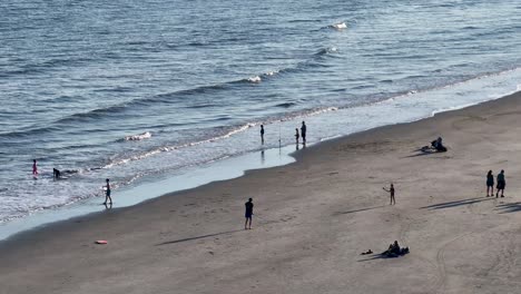 Tourists-play-on-the-sandy-beaches-of-Charleston-South-Carolina-in-the-long-shadow-late-evening