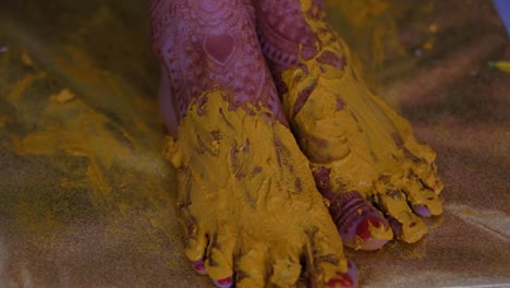 Turmeric-Paste-On-Bride's-Feet-During-Pithi-Ceremony-Celebration---Close-Up