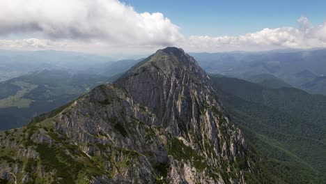 Breathtaking-aerial-view-of-the-sharp-peak-in-Piatra-Craiului-Mountains-under-clear-skies