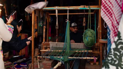 Tourists-filming-Local-traditional-carpet-maker-showing-the-process-of-traditional-carpet-making,-Nubian-village,-Aswan,-Egypt