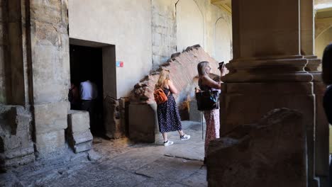 Historic-building-in-Bath,-England-with-tourists-and-gimbal-video-walking-sideways-in-slow-motion