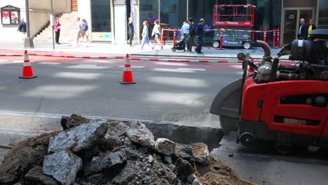 Eine-Straßenansicht-Eines-Mannes,-Der-An-Einem-Sonnigen-Tag-Mit-Einer-Maschine-Eine-Linie-Schneidet,-Um-Einen-Graben-Entlang-Der-Fifth-Avenue-In-New-York-Auszuheben