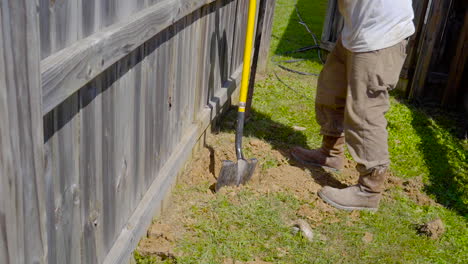 Man-begins-to-dig-a-hole-with-a-shovel-for-fence-repair