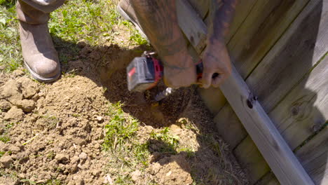 Drilling-out-old-fence-post,-high-angle