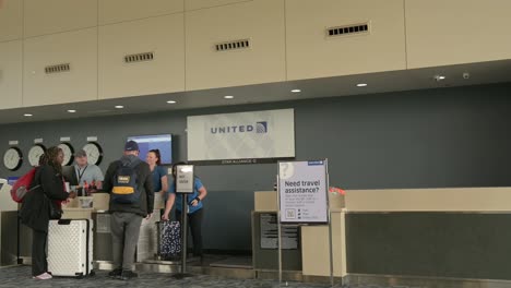 Personen-Beim-Check-in-Von-United-Airlines-Am-North-Bend-Airport,-Schwenkaufnahme