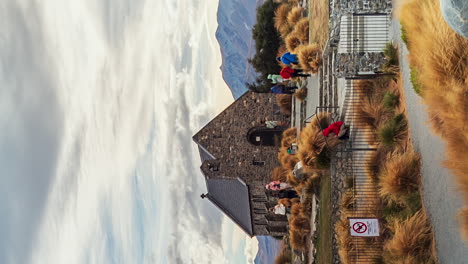 Vertical-format-of-tourists-exploring-Good-Shepherd-Church-Tekapo,-New-Zealand-timelapse