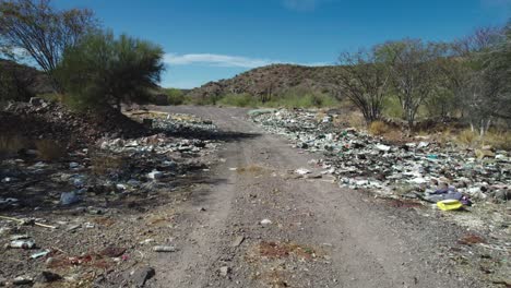 Basura-A-Lo-Largo-De-La-Carretera-Que-Resta-Valor-Al-Paisaje-Desértico-De-Mulegé,-Baja-California-Sur,-México---Drone-Volando-Hacia-Adelante