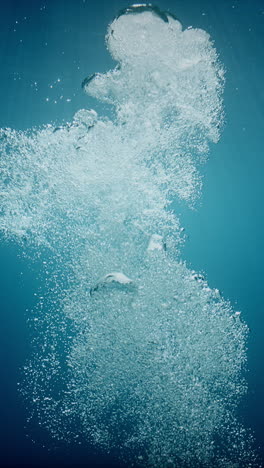 Sunlight-beams-filter-through-the-deep,-crystal-clear,-blue-turquoise-water,-casting-a-beautiful-curtain-of-reflections