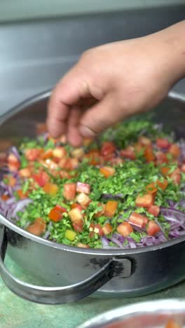 Mano-Tirando-Trozos-De-Tomate-Fresco-En-Ensalada-Peruana,-Cámara-Lenta