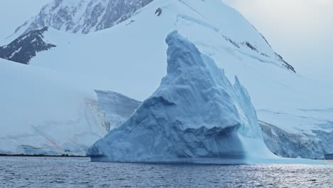 Calentamiento-Global-Derritiendo-Iceberg-Debido-Al-Cambio-Climático-En-La-Antártida,-Increíble-Formación-De-Hielo-Flotando-En-El-Océano,-Formas-De-Icebergs-Azules-De-La-Antártida-En-El-Agua-De-Mar-De-La-Península-Antártica-En-El-Paisaje-Marino-De-Invierno