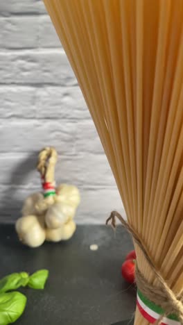Espaguetis-Italianos-Verticales-Pasta-Bandera-De-Italia-Cocina-Tomate-Ajo-Albahaca-Vista-Atada-Con-Cuerda,-Cocina-Con-Ingredientes-Para-Cocinar-De-Cerca-Girando