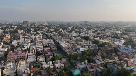 A-mesmerizing-aerial-view-of-Chennai-city,-with-clouds-drifting-lazily-over-the-bustling-streets-and-towering-skyscrapers,-creating-a-captivating-scene