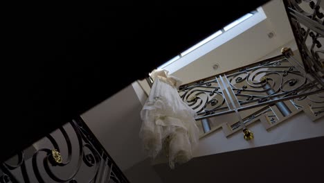 Bridal-gown-hanging-on-a-staircase-with-wrought-iron-balustrade