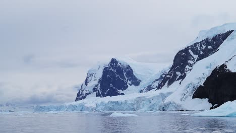 Glacier-and-Mountains-at-Sunset-on-Coast,-Antarctica-Mountain-Landscape-of-Coastal-Scenery,-Blue-Winter-Scene-with-Ice-and-Ocean-Sea-Water,-Antarctic-Peninsula-Seascape-in-Beautiful-Dramatic-Scene