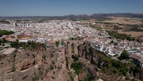 aerial-tilt-down-video-of-Bridge-Tajo-de-Ronda-Gorge-and-bullring-in-Ronda,-Andalusia,-Spain