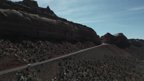 A-solitary-camper-truck-travels-the-highway,-crossing-the-barren-landscapes-of-Utah,-USA,-embodying-van-life,-a-lifestyle-marked-by-freedom,-exploration,-and-the-ceaseless-adventure-of-the-open-road